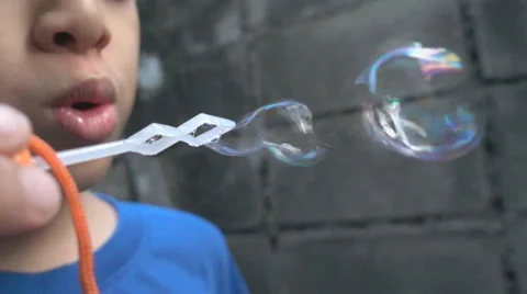 Slow motion boy blowing bubble soap Stockbeeldmateriaal 65801097