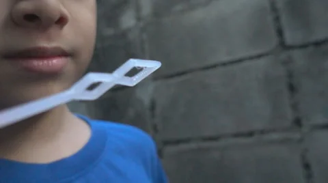 Slow motion boy blowing bubble soap Stockbeeldmateriaal 65801435