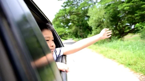 Slow motion Boy in car waving hand during travel Stock Footage 77631789
