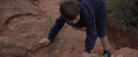 Slow Motion Boy Climbing and Jumping on Rocks Stock Footage 61836875