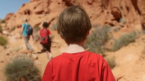 Slow motion - boy hiking through desert with mom and brother on hot day Stock Footage 100566861