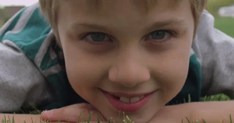 Slow Motion Boy Lies on His Stomach and Smiles Stock Footage 61521642