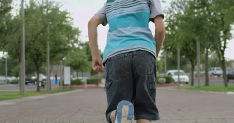 Slow Motion Boy on a Path in a Park Running Away Stock Footage 61652158
