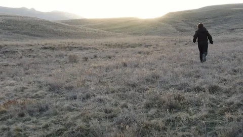 Slow motion boy running down the hill on the sunset background Stock Footage 104908354