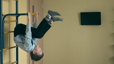 Slow motion: boy, in school uniform, makes a coup on the sports ladder. Stock Footage 105101731