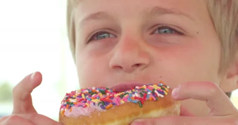 Slow Motion Boy Takes Bite out of Donut Stock Footage 61468333