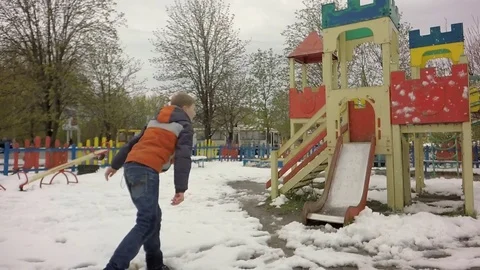 Slow motion. The boy throws snow on the playground. Stock-Footage 74870191