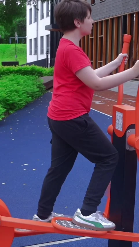 Slow Motion Boy Training on Outdoor Air Walker in Public Fitness Park Stock Footage 338013677