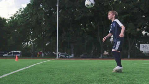 SLOW MOTION - Boy trains professionally on a football field with a ball. Trai Stock Footage 194402600