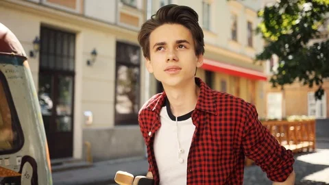 Slow motion boy using a mobile phone walk look around smile keeps skate guy Video stock 92050758