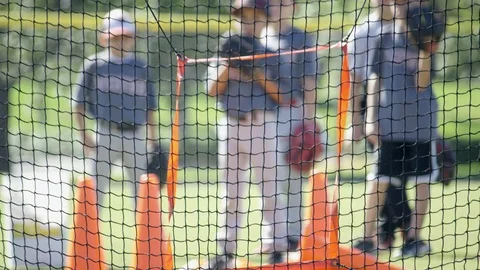 Slow motion of boys throwing ball to a net during baseball practice Stock Footage 93716703