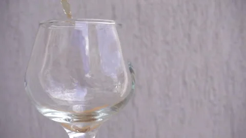 Slow motion of brandy pours into an empty wine glass. Stock Footage 112366967