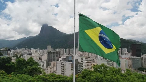 Slow motion of a Brazilian flag with background of Christ the Redeemer Stock Footage 231001692