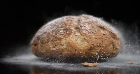 Slow motion of bread being dropped and creating dust and particles in the air Video stock 343289780