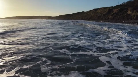 Slow Motion Breaking Ocean Wave Near Coastline at Sunset in 4K Vídeo Stock 332944619