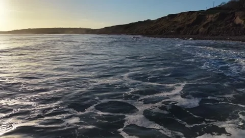 Slow Motion Breaking Ocean Wave Near Coastline at Sunset in 4K Stock Footage 332944621