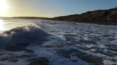 Slow Motion Breaking Ocean Wave Near Coastline at Sunset in 4K Stock Footage 332944635
