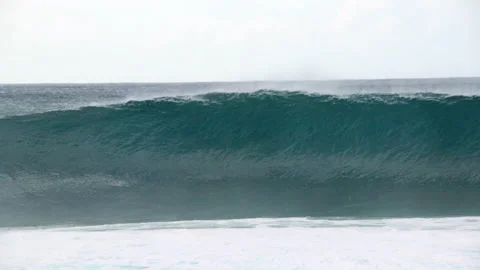 Slow Motion Of A Breaking Wave As It Passes By A Group Of Paddling Surfers - Stock Footage 158902353