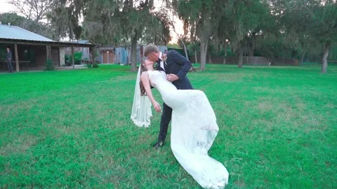 Slow-motion of a bride and groom dancing and kissing in the garden Vidéo 220126424