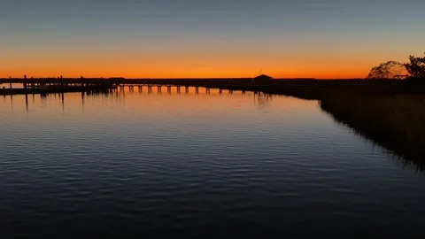 Slow-motion of a bridge and dock mirrored in calm twilight water... Stock Footage 322811757