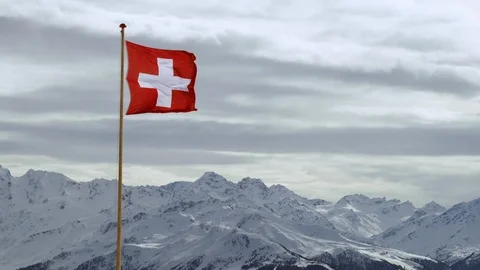 Slow motion of brightly colored Swiss flag with white cross waving in breeze Stock Footage 129094379