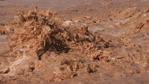 Slow motion of brown water rapids splashing on flooded river after storm rain Stock Footage 233914040