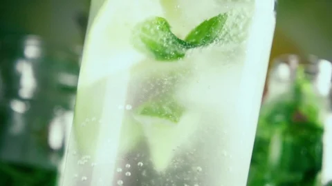 Slow motion bubbles in a glass of sparkling water and lime Stock Footage 92320375