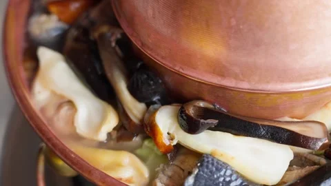 Slow-Motion Bubbling Tibetan Wild Mushroom Hot Pot with Copper Cookware Stockbeeldmateriaal 312485960