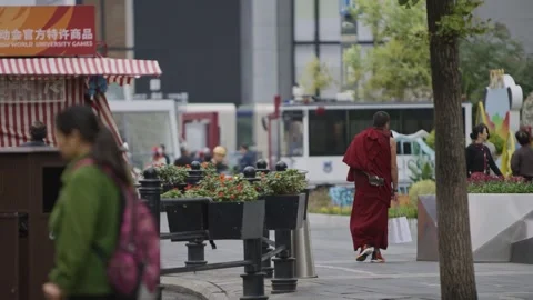 Slow motion of Buddhist monk with mobile phone walking past modern altar Chengdu Stock Footage 315173974