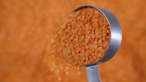 Slow motion bulk dry red lentils tipping a portion of legumes Stock Footage 88337302