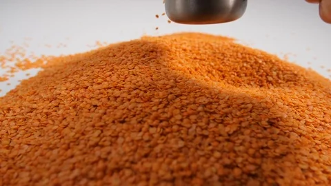 Slow motion bulk dry red lentils with a portion of legumes scooped  Stock Footage 88338197