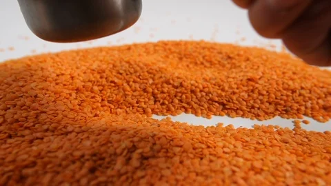 Slow motion bulk dry red lentils with man white trail scooping a portion Stock Footage 88338424