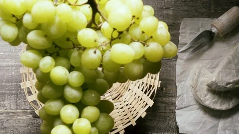 Slow motion a bunch of grapes falls into the basket on the table top view Stock Footage 93699335