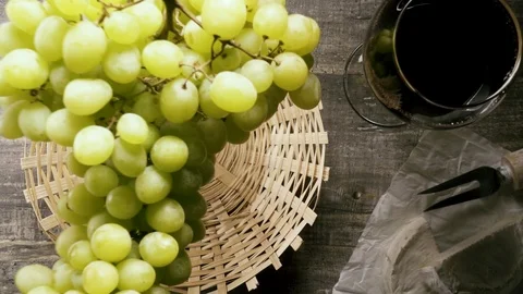 Slow motion a bunch of grapes falls into the basket on the table top view Stock Footage 93699452