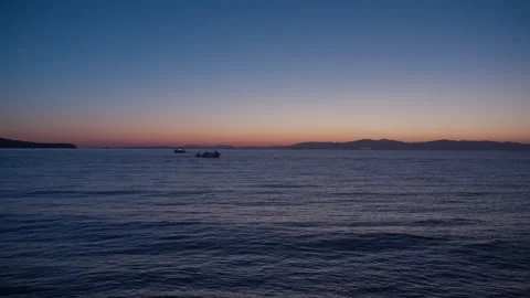 Slow Motion of Calm Deep Blue Sea and Orange Twilight Glow on the Horizon at Stock Footage 344135104
