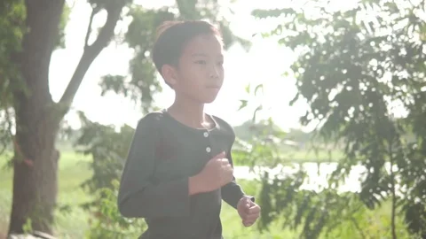 Slow motion camera follow young Asian boy running  库存影片 114691679
