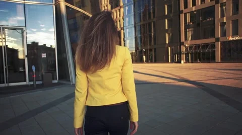 Slow motion. Camera following to Young beautiful girl in a yellow jacket which Stock Footage 65402459