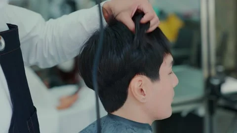 Slow motion camera movement. After the professional barber cut the hair, use  Stock Footage 153821739