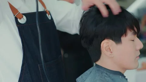 Slow motion camera movement. After the professional barber cut the hair, use  Stock Footage 153964721