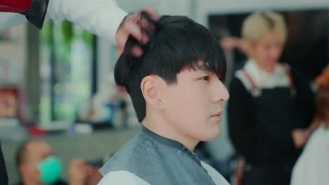 Slow motion camera movement. After the professional barber cut the hair, use  Stock Footage 153964776