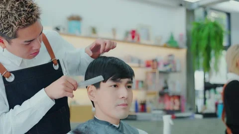 Slow motion camera movement. Professional barber cuts men using scissors and 스톡 동영상 153969074