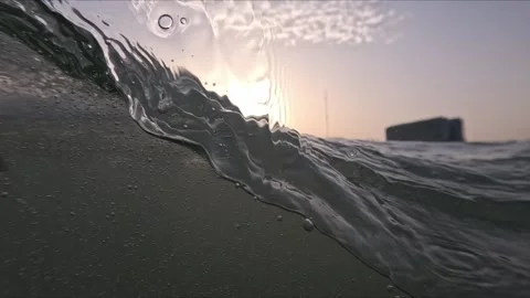 Slow motion camera movement through ocean waves shows underwater bubbles dr.. Stockbeeldmateriaal 344101002