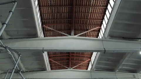 A slow-motion camera moves along a large gray high empty storage room in a facto Stock Footage 111368486