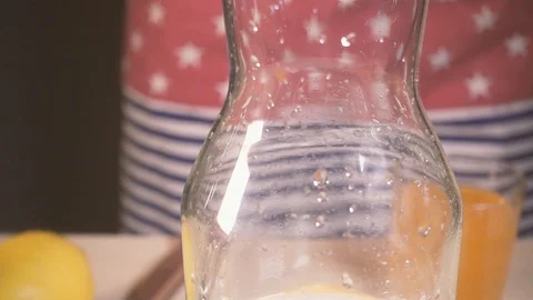 Slow motion the camera moves down the decanter and the orange falls down Stock Footage 87946163