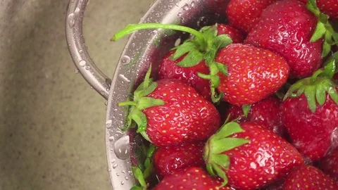 Slow motion the camera moves over a sink with a strawberry in a colander Video stock 90257669