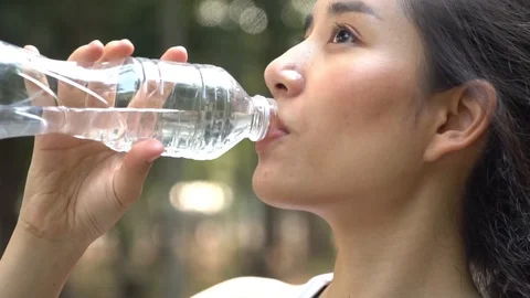 Slow motion camera panning and focus at young woman drink water fro Stock Footage 124364911