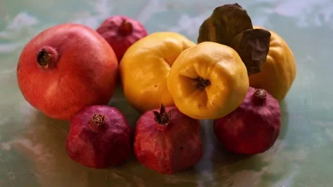 Slow motion camera panning of ripe yellow quinces with green leaves and red pome Stock-Footage 341616895