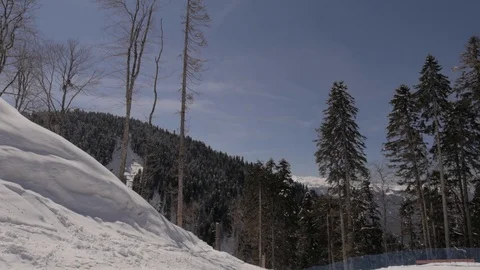 Slow motion camera in the snowy mountains along the ski slope overlooking the na Stock Footage 127589901