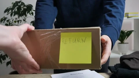 The slow-motion capture emphasizes the careful transfer of a returned item Stock-Footage 318580826