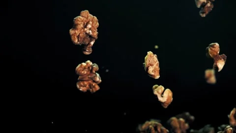 Slow Motion Capture of Fresh Walnuts Tumbling Down in a Dark Studio Stock Footage 272188679